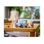 LEGO set featuring a blue Flying Ford Anglia™, minifigures, a suitcase, and a white owl on a wooden table.