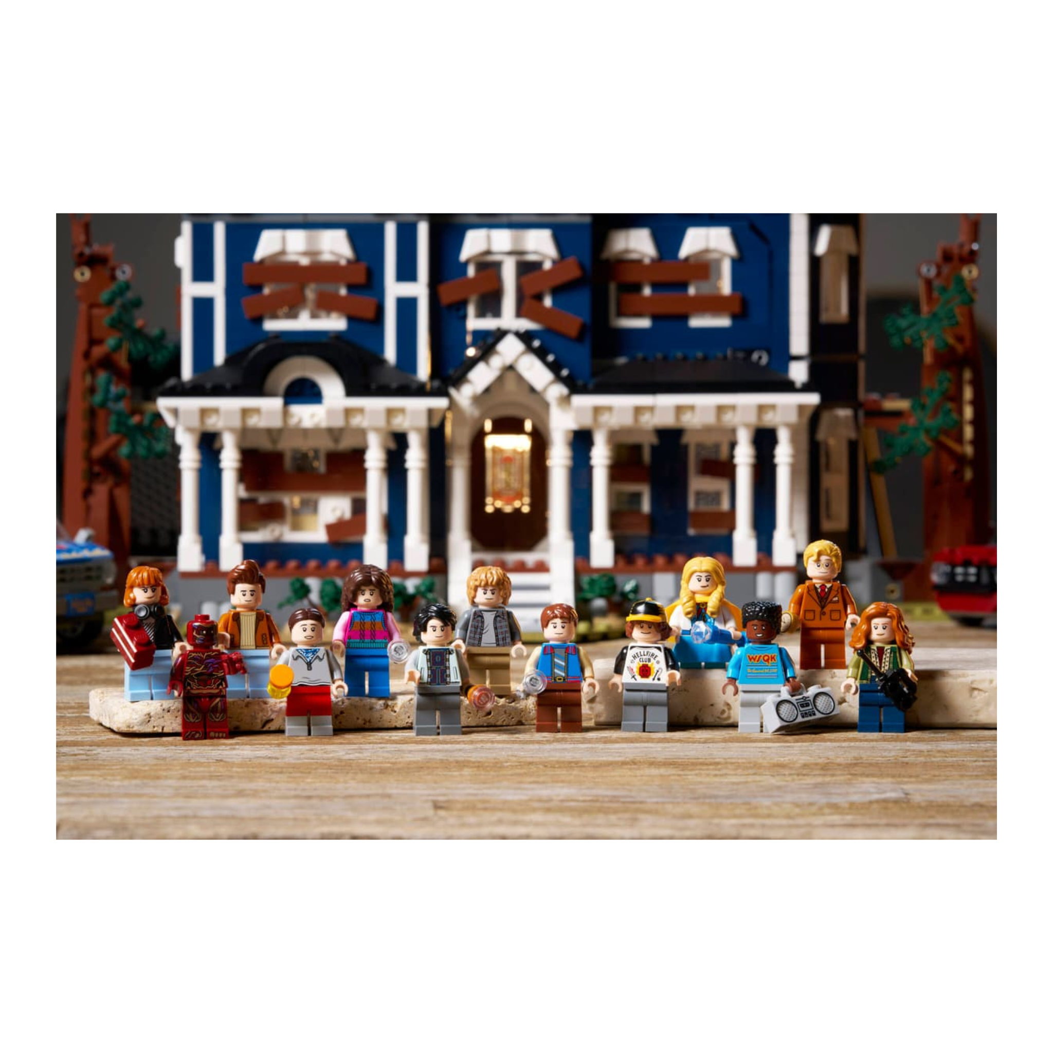 LEGO minifigures from Stranger Things in front of a detailed blue house with white trim and multiple windows.
