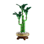 Model of LEGO Lucky Bamboo featuring green stalks and leaves on a circular base with stone-like elements.