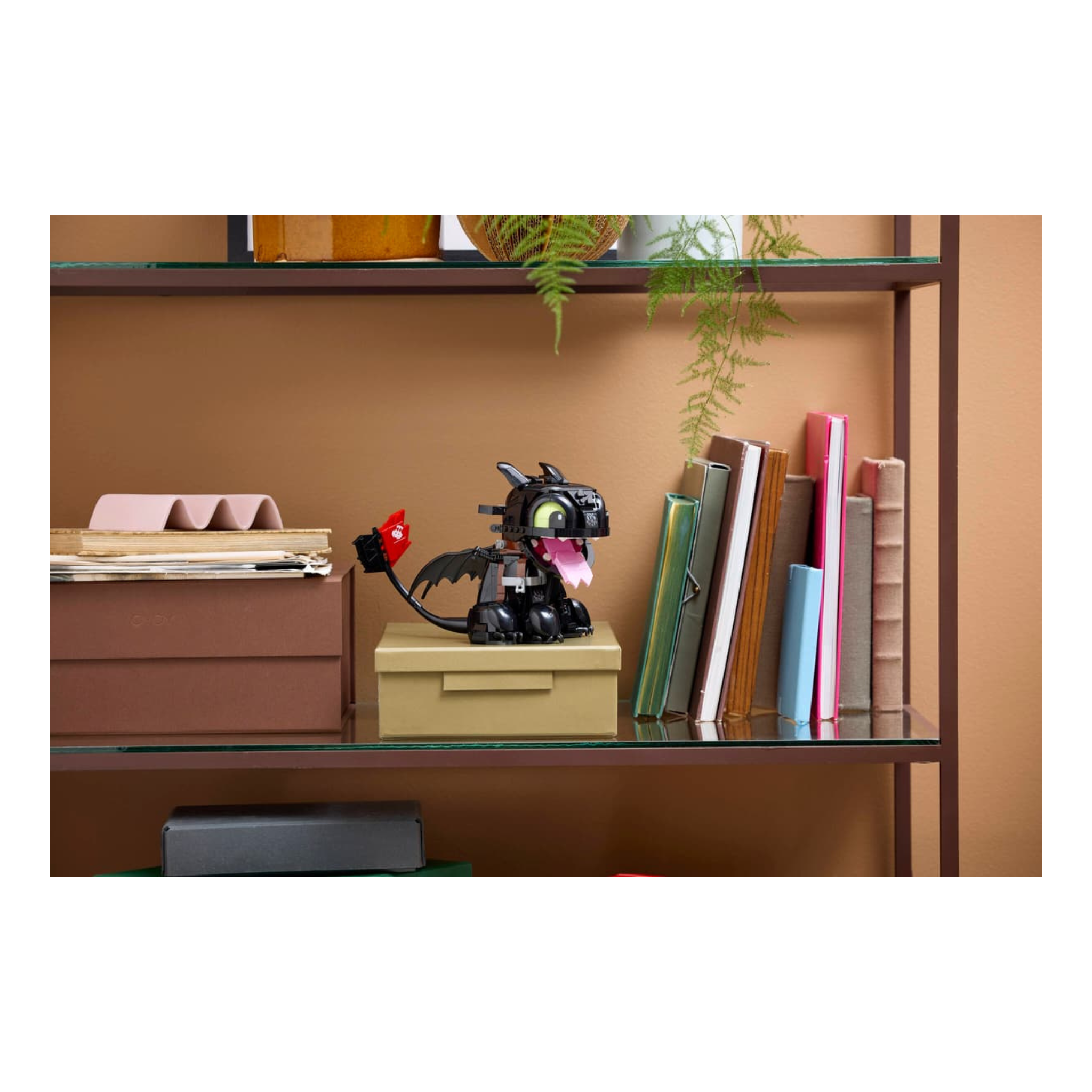 LEGO model of Toothless from How to Train Your Dragon displayed on a shelf with books and decorative items.